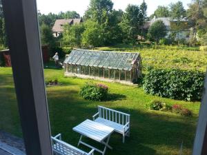 莱西Kuus Tuba的享有花园的景色,花园设有2个长椅和温室