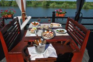 奥林普Lacul Racilor的船上的餐桌,上面有食物和葡萄酒