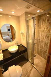 马尔马里斯马尔马里斯城市酒店的一间带水槽、淋浴和镜子的浴室