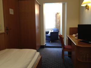 巴特诺因阿尔-阿尔韦勒霍亨索伦酒店的酒店客房配有一张床、一张桌子和一把椅子。