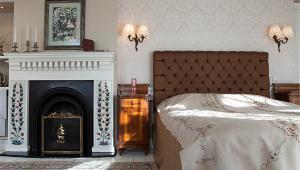 伯萨齐塔佩维酒店 的一间卧室配有一张床和一个壁炉