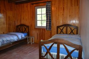 Sainte-Eulalie-en-BornLa Maison Ratabou的配有木墙和窗户的客房内的两张床