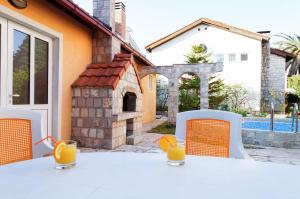 比耶拉Apart Hotel Apple Cat Montenegro KO Bijela的一张带橙色椅子的白色桌子和橙汁