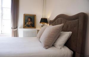 魁北克市玛丽 - 罗列特酒店的卧室,配有一张床和一张女人的肖像
