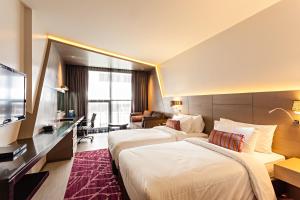 曼谷贝斯特韦斯特倍加素坤逸1号的酒店客房设有两张床和电视。