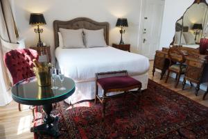 魁北克市玛丽 - 罗列特酒店的一间卧室配有一张床、一张桌子和一架钢琴