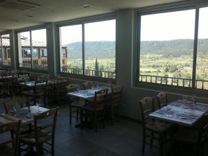 穆斯捷-圣玛丽贝尔福德里酒店的用餐室设有桌椅和窗户。