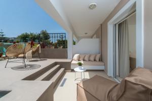 卡拉马孔Bitzaro Grande Hotel & Suites的阳台设有带沙发和椅子的客厅