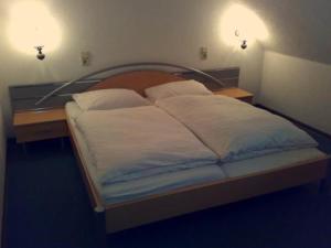 巴特伊堡皇家花园酒店的一间卧室配有一张床、两个床头柜和两个灯