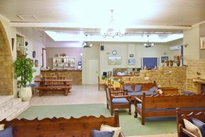 斯基罗斯岛Achilleion Hotel的一间设有木椅和桌子的等候室