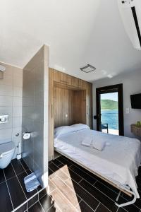 阿莫利亚尼岛Pension Limani的一间卧室配有一张床、一个浴缸和一个水槽