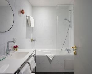 巴黎马尔特阿斯托特尔酒店的白色的浴室设有浴缸和水槽。