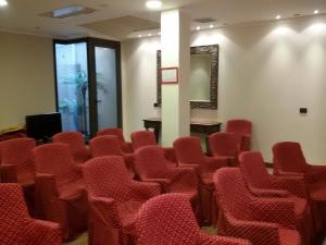 西尔米奥奈米斯特拉尔帆船酒店的一间空房间,配有红色的椅子和桌子