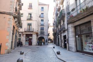 赫罗纳Bravissimo Cort Reial-3A的建筑物之间的小巷里一条空的街道