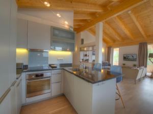卡普伦卡普伦租赁克兹坦布里克公寓的厨房配有白色橱柜和木制天花板