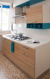 利多康奇耶Appartamento La Vela的厨房配有水槽和炉灶 顶部烤箱