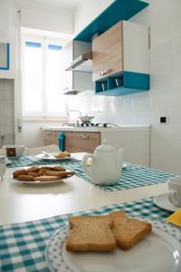 利多康奇耶Appartamento La Vela的厨房配有带面包和茶壶的桌子