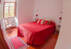 圣地亚哥－德孔波斯特拉塔斯拓恩崔拉斯公寓的一间卧室配有红色的床和红色毯子