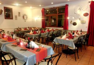 圣拉里苏朗VVF Saint-Lary-Soulan Hautes-Pyrénées的一间配备有桌椅和红色窗帘的用餐室