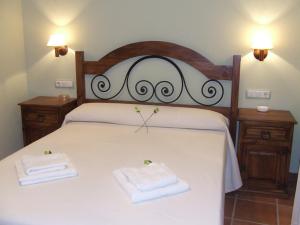 Zarzuela del MonteLos Herrero的一间卧室配有一张床,上面有两条毛巾