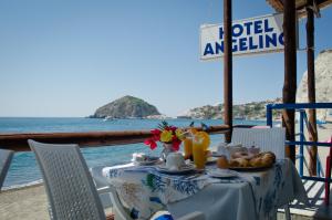 伊斯基亚Hotel Angelino的一张带食物的桌子,享有海景