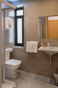 滨海阿雷尼斯波托菲诺宾馆的一间带卫生间、水槽和镜子的浴室