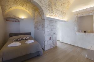 奥斯图尼Vico Potenza 3的一间卧室设有一张床和石墙