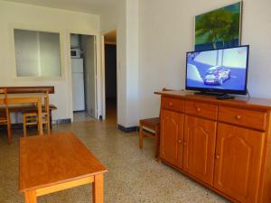 拉皮内达CYE 5 Rentalmar的客厅配有带平面电视和木制梳妆台