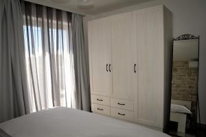 班约勒APP Rab Banjol 217的卧室配有白色的床和镜子