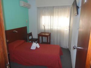 杜拉斯诺Hotel Central的一间卧室配有红色的床和2条毛巾