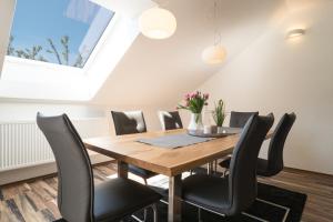 美因茨MA-LIVING Miralior Apartment Mainz的用餐室配有木桌和黑椅子