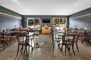 坎贝尔敦Quest Campbelltown的用餐室配有桌椅和平面电视。