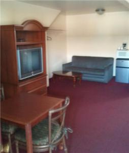 温泉城温泉城三叶草汽车旅馆的客房设有桌子、电视、桌子和椅子。