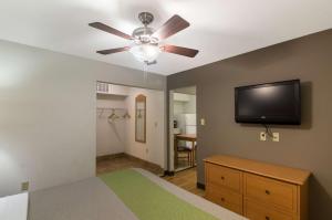 拉伯克Studio 6-Lubbock, TX - Medical Center的一间卧室配有吊扇和一台平面电视。
