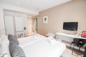 马德里珀蒂宫太阳门酒店的酒店客房设有两张床和电视。