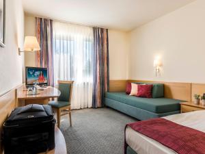 慕尼黑艾玛慕斯菲尔德酒店的酒店客房,配有床和沙发