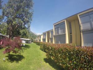 多马索露营维拉吉奥天堂酒店的前面一排公寓楼,有灌木丛