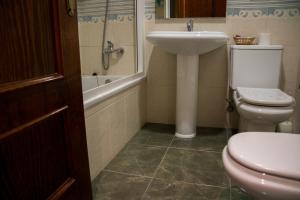 阿德拉Hostal Restaurante La Curva的浴室配有卫生间、盥洗盆和浴缸。