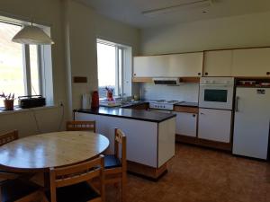 达尔维克霍撒巴克宾馆的厨房配有桌子和白色冰箱。