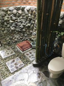 ManinjauEka's Bungalows的一间带卫生间和石墙的浴室