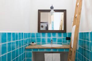 圣马里纳萨利纳Hotel Mercanti di Mare的蓝色瓷砖浴室设有水槽和镜子