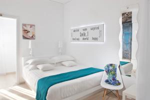 卡马利圣托里尼阿克库瓦瓦托斯酒店的白色卧室配有床和椅子