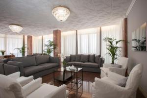 利多迪耶索罗Hotel Imperial Palace的带沙发和桌子的客厅以及窗户。