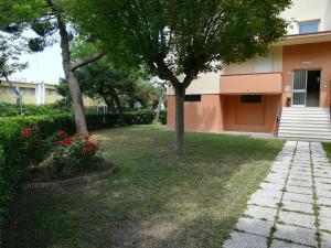 丽都阿德里亚诺奥罗拉住宅酒店的院子里有树木和鲜花的房子