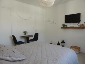 安锡Le "Wood"的白色卧室设有一张床和墙上的电视