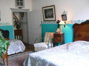BuxyChambres d'hôtes la Graineterie的一间卧室设有两张床和蓝色的墙壁
