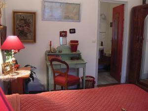 BuxyChambres d'hôtes la Graineterie的一间卧室配有书桌、椅子和床