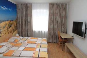 林茨Appartementhaus Anna的一间卧室配有一张床、一张书桌和一台电视
