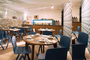 巴黎索菲杰曼酒店的餐厅设有木桌和蓝色椅子