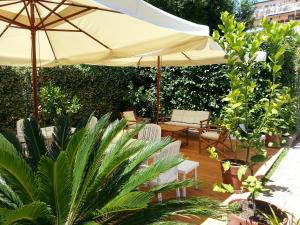 加埃塔B&B Villa Fantasia的一个带遮阳伞、椅子和植物的庭院